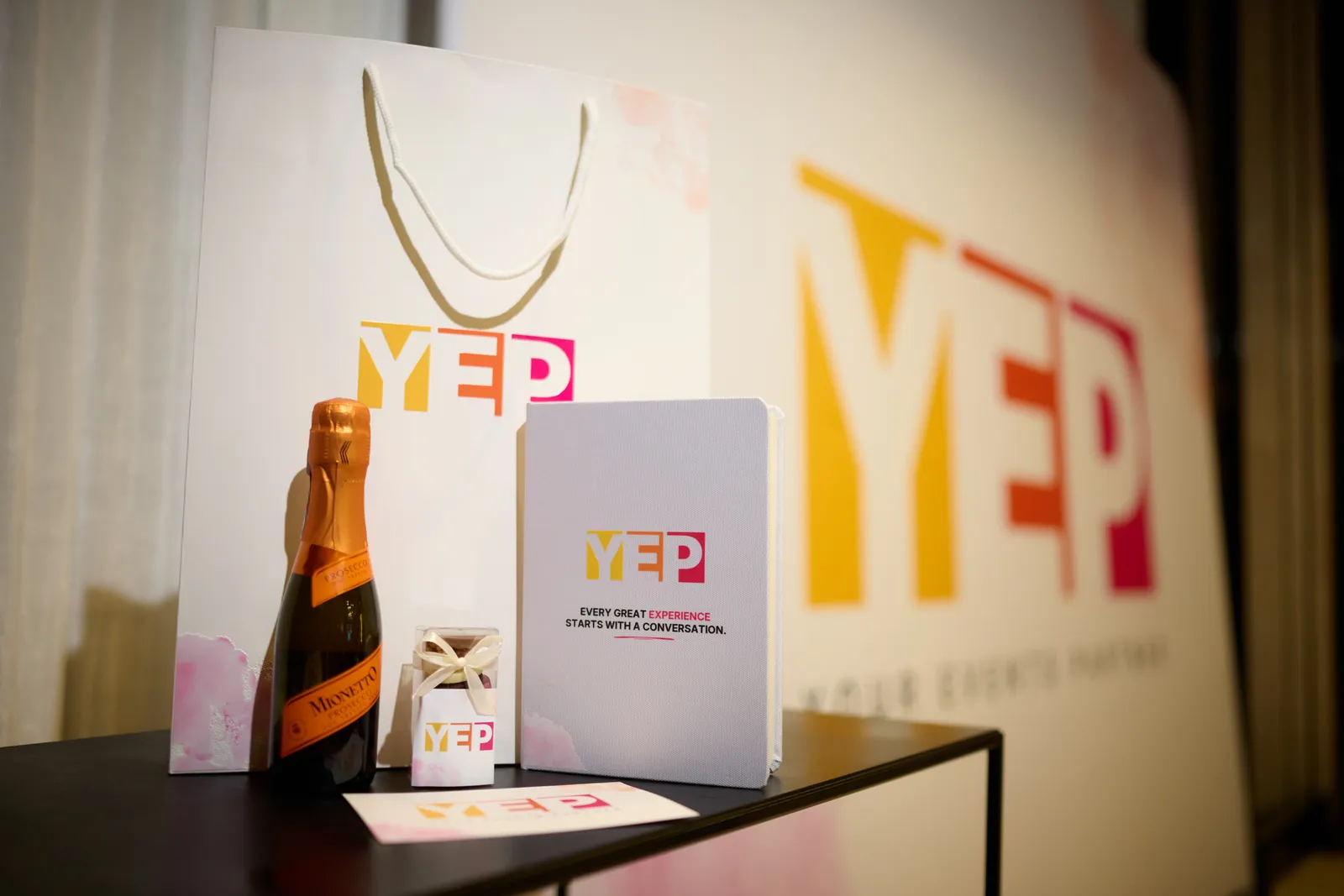 The gift bag contents: prosecco, chocolate and the notebook that reads every great experience starts with a conversation