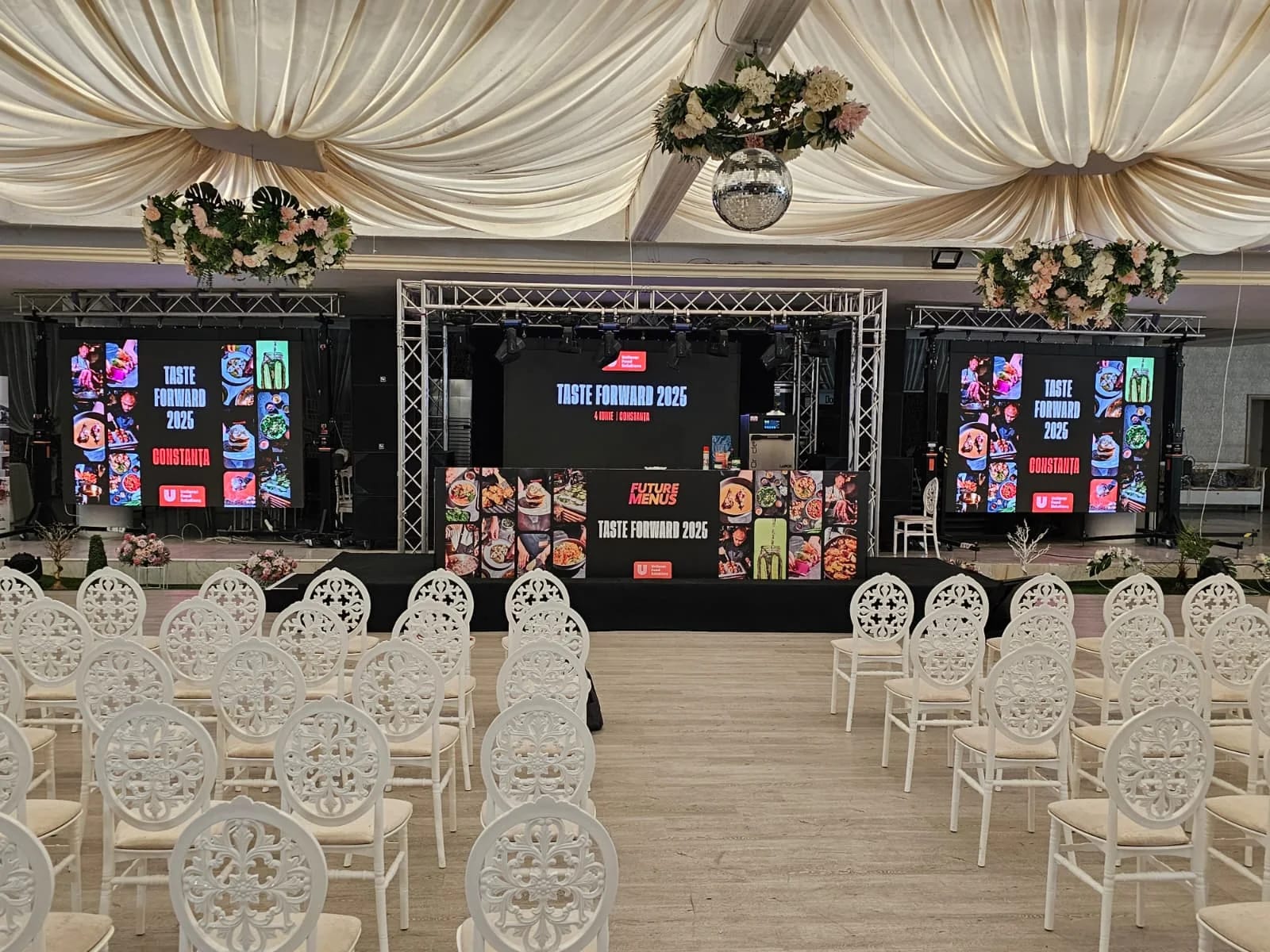 UniChef Cup 2025 event room in Mamaia with stage, branded screens and audience seating.