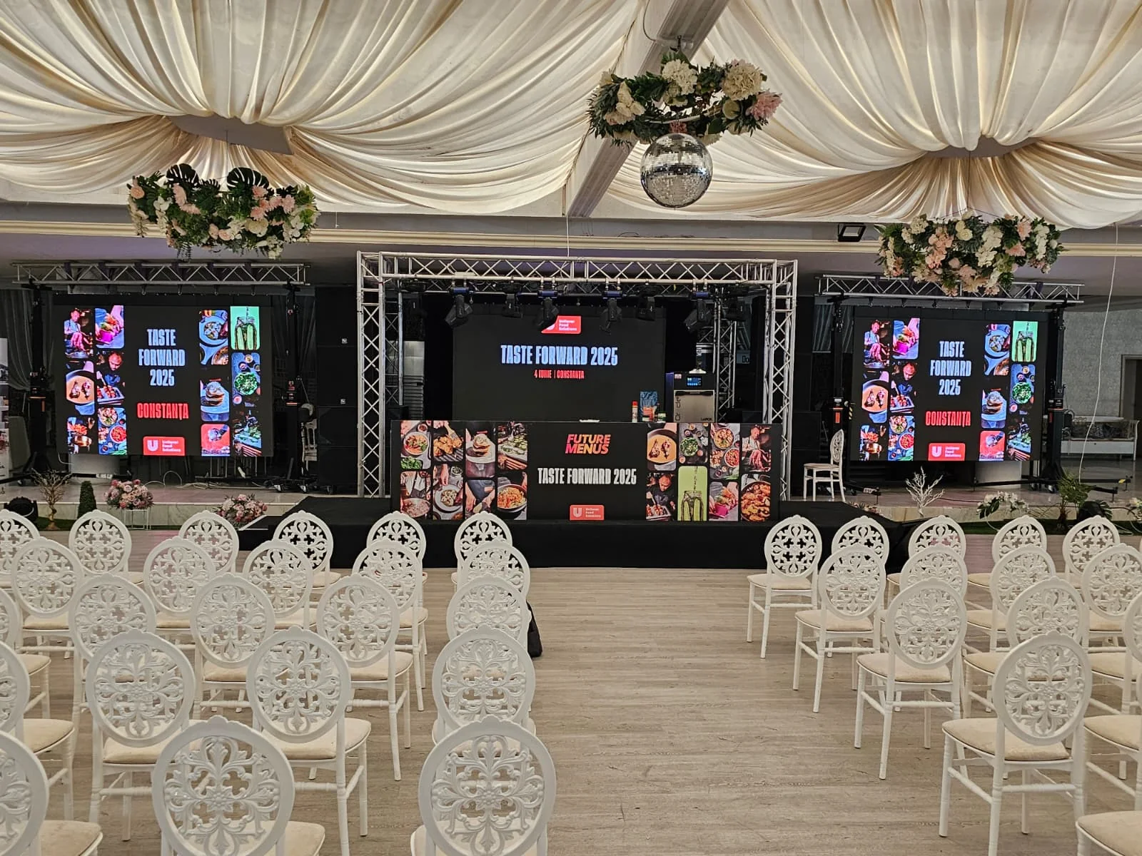 UniChef Cup 2025 event room in Mamaia with stage, branded screens and audience seating.