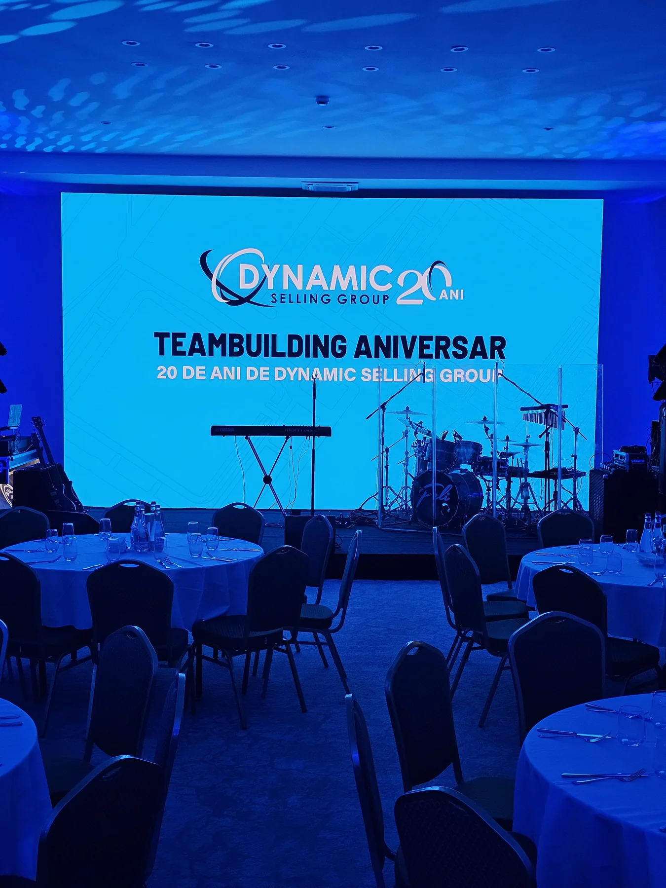 Portrait view of the Dynamic Selling Group anniversary stage with LED content and blue event lighting in Sinaia.