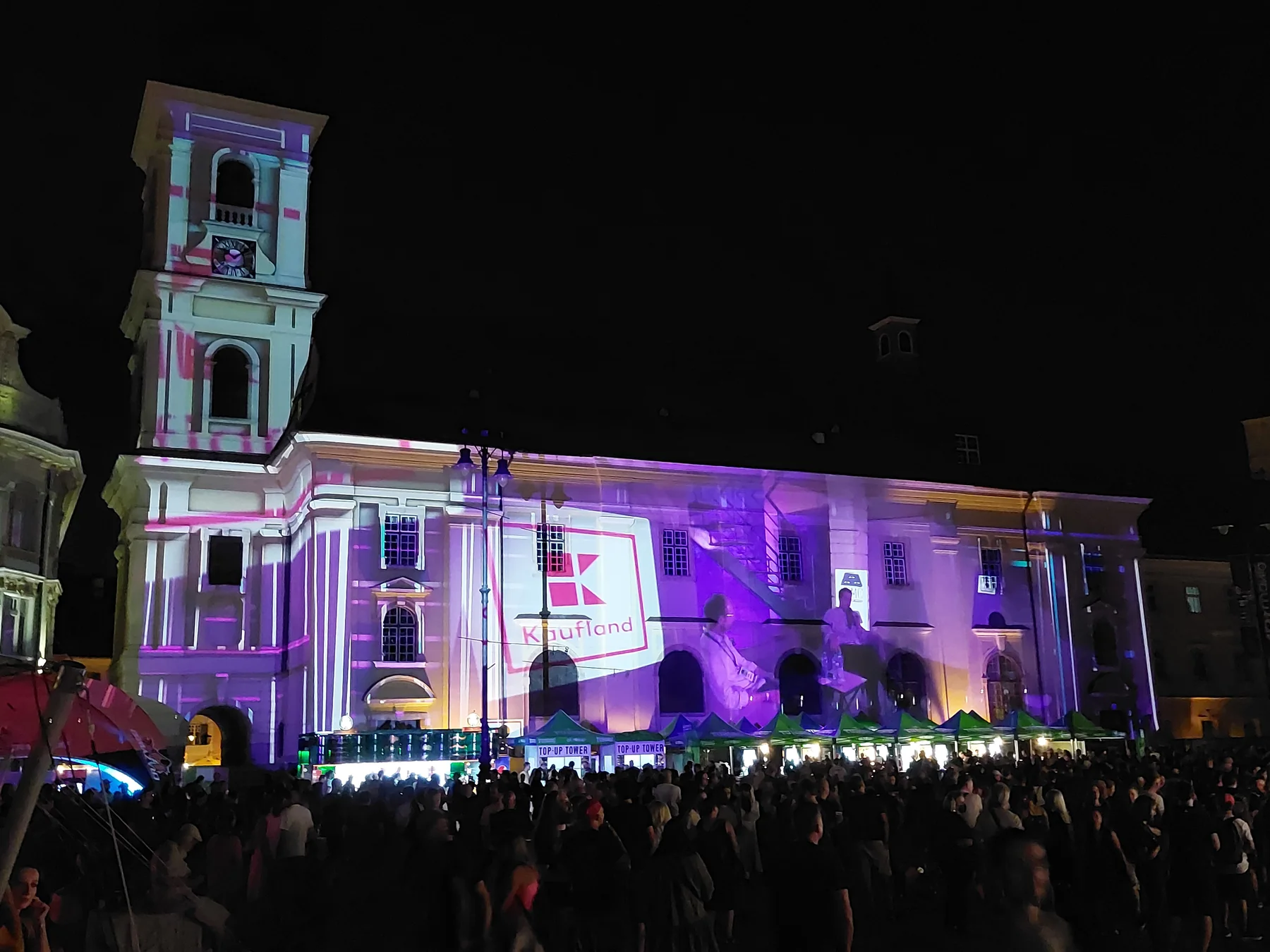 Wide view of the Artmania building projection in Sibiu with the crowd gathered in Piața Mare.