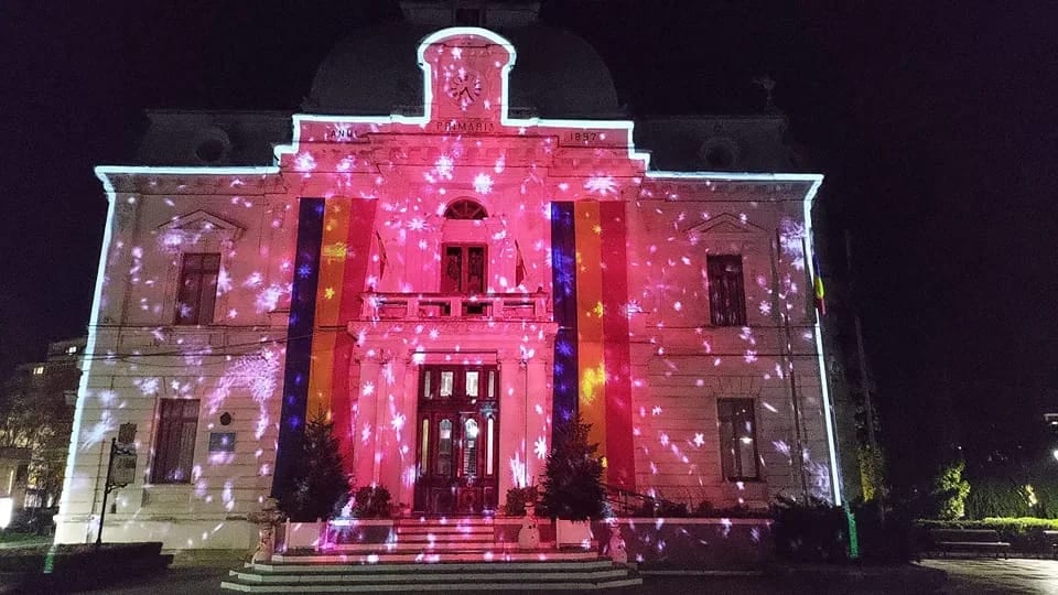 Dynamic projection covering the Târgoviște City Hall facade at night.