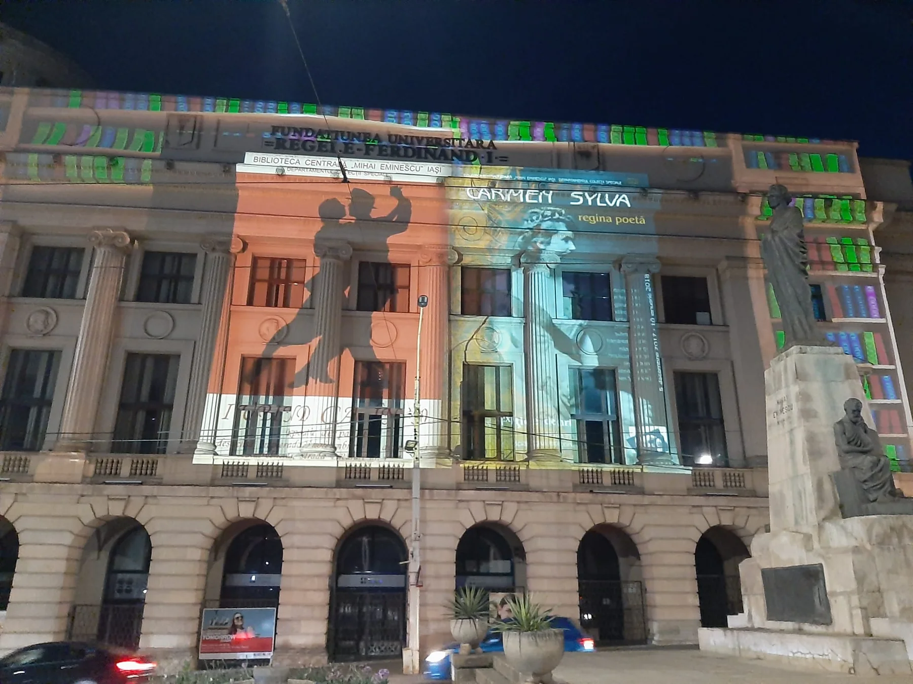 Projection across the Biblioteca Centrală Universitară facade in Iași at night.