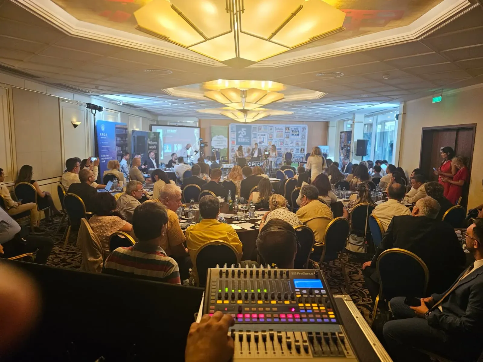 Conference audience and audio control position during the Business Review event at Crowne Plaza in Bucharest.
