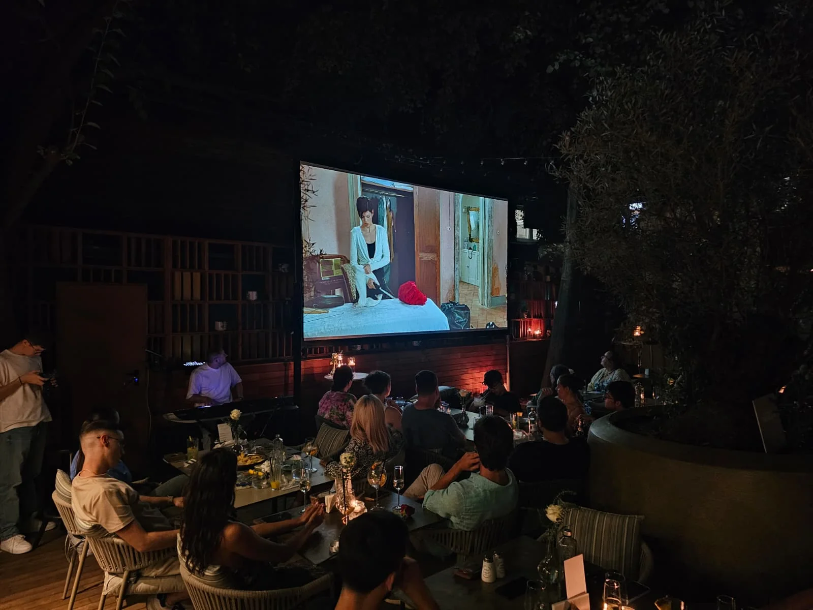 Audience watching film content on the outdoor projection screen at the Blue Restaurant event in Bucharest.