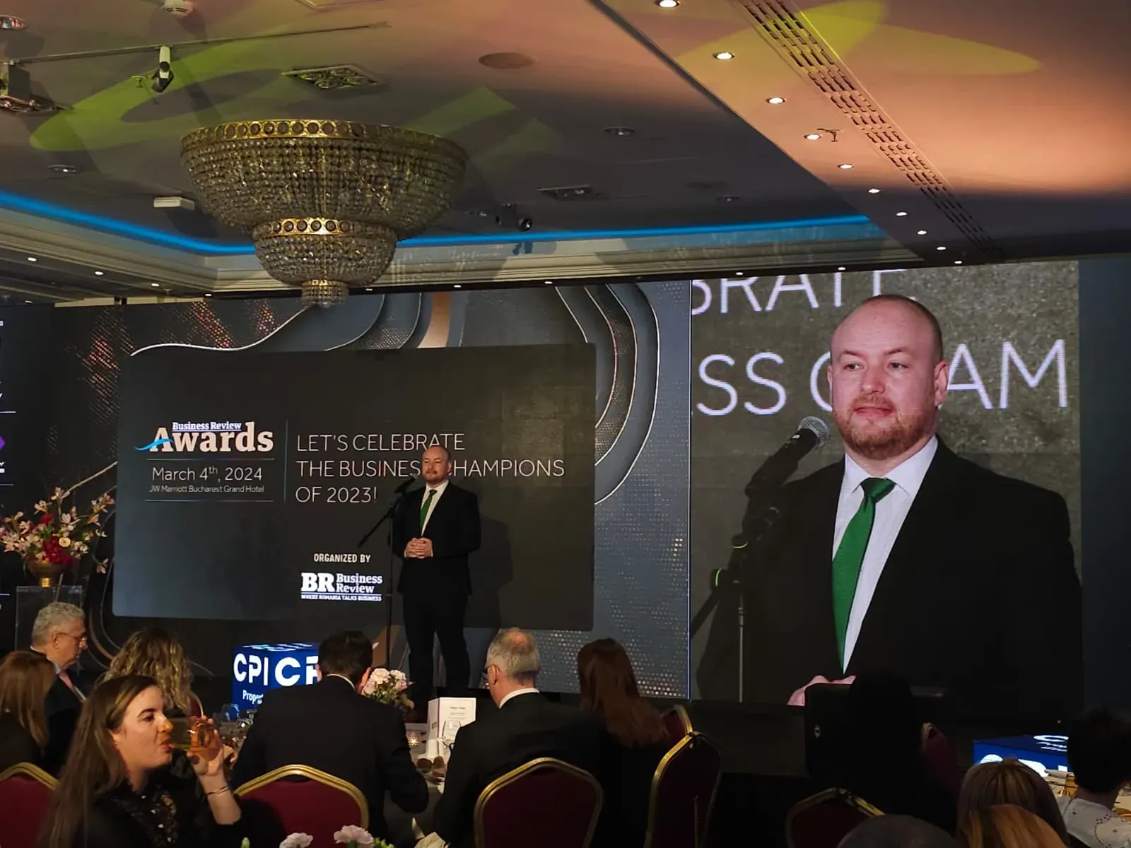 Large LED stage showing a speaker during the Business Review conference at Grand Hotel Marriott in Bucharest.