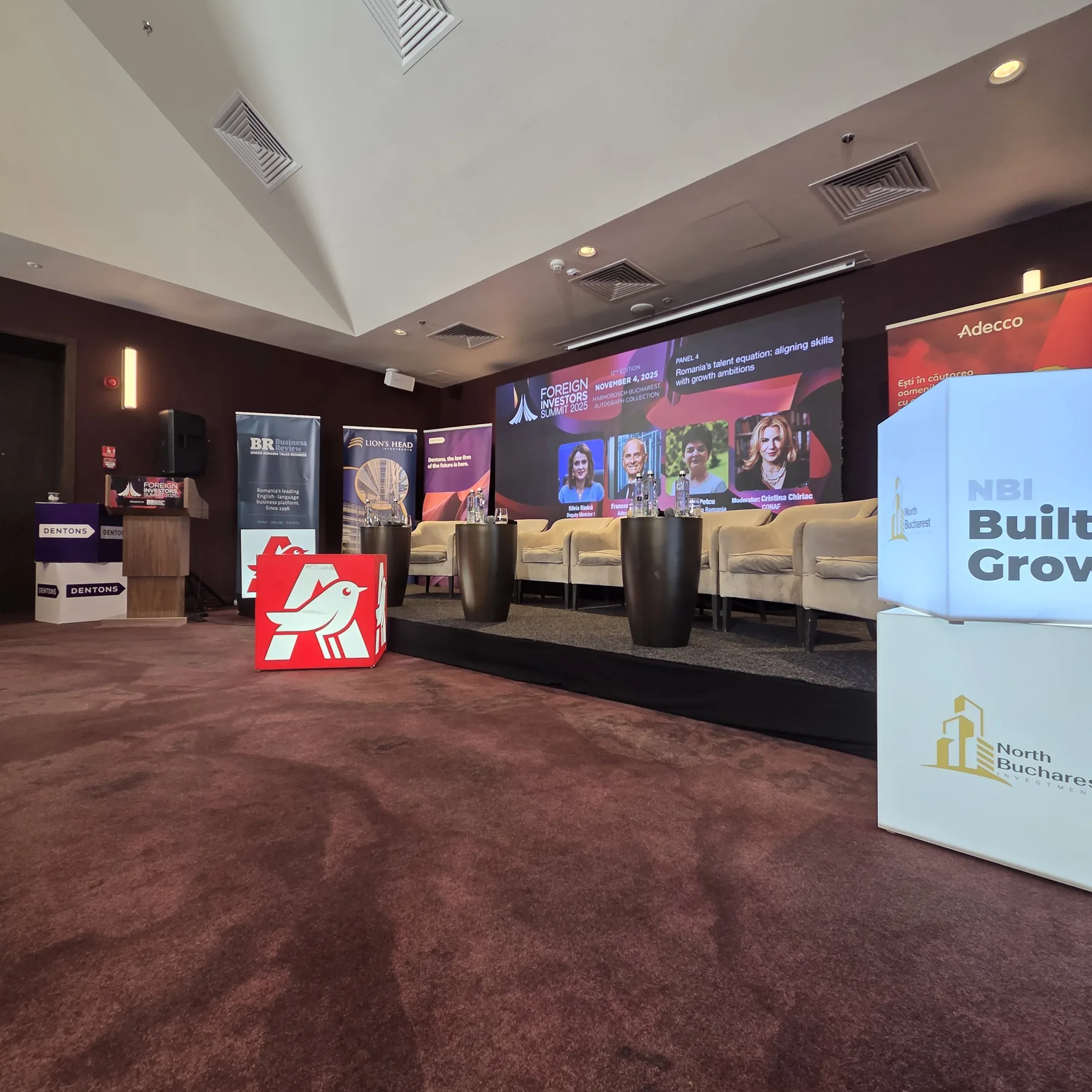 Side view of the stage, LED backdrop and branded event cubes at the Business Review Foreign Investors Summit 2025 at Hotel Marmorosch in Bucharest.