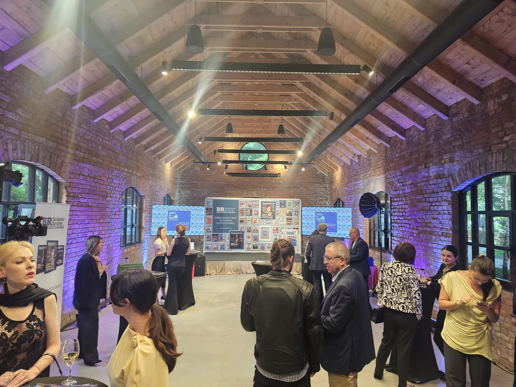 Guests inside Caro Atelier during the Business Review event with professional displays and event lighting.
