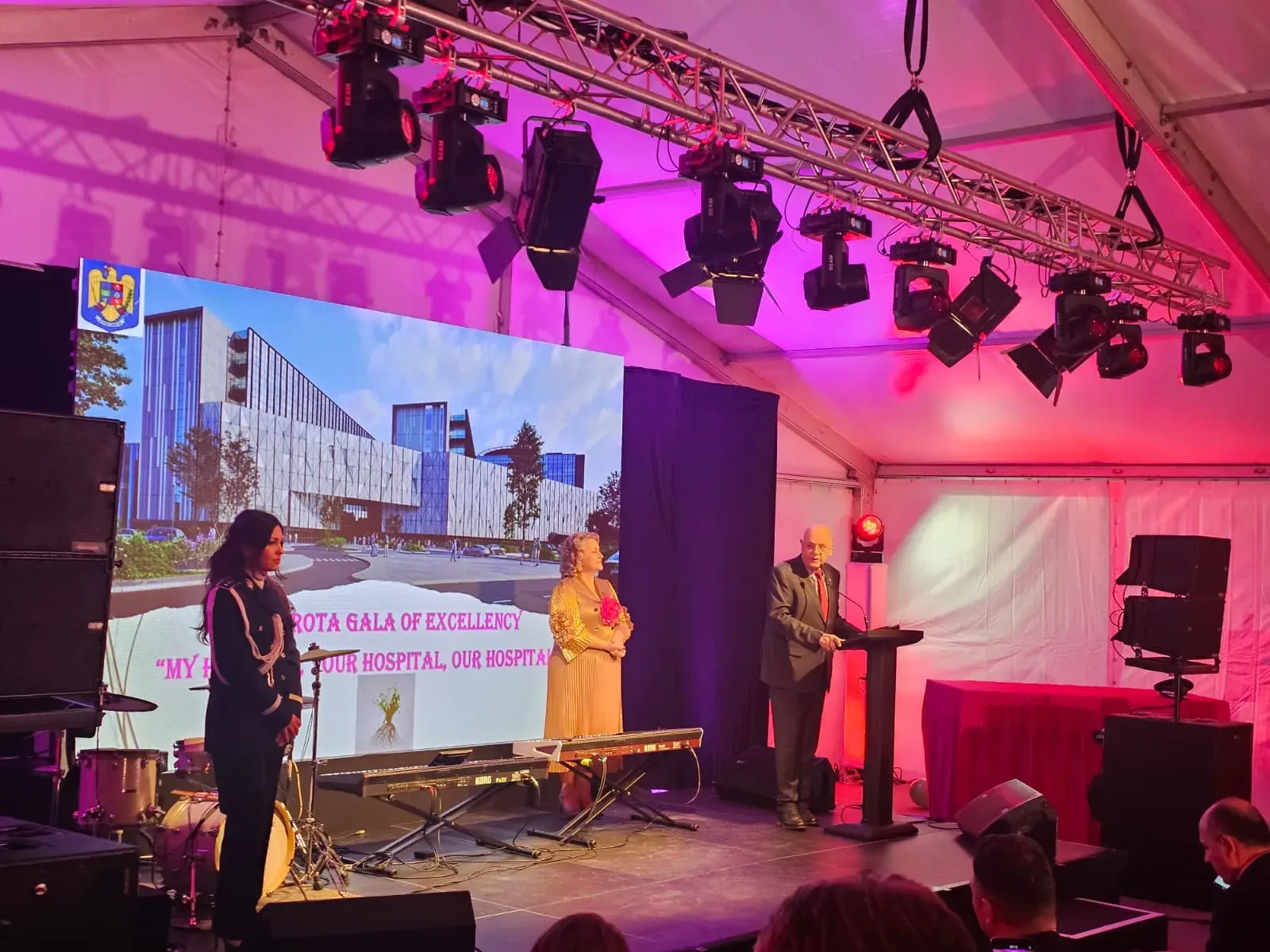Speakers on the illuminated LED stage during the Dimitrie Gerota Hospital construction-site inauguration in Bucharest.