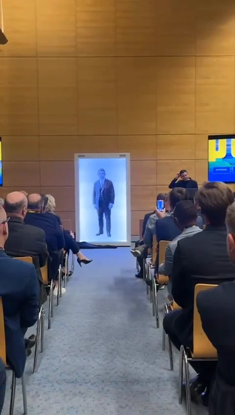 Audience viewing a full-height digital presenter inside the PORR Holobox holographic display at Pyramide Eventhotel Congress Lake Resort in Vienna.