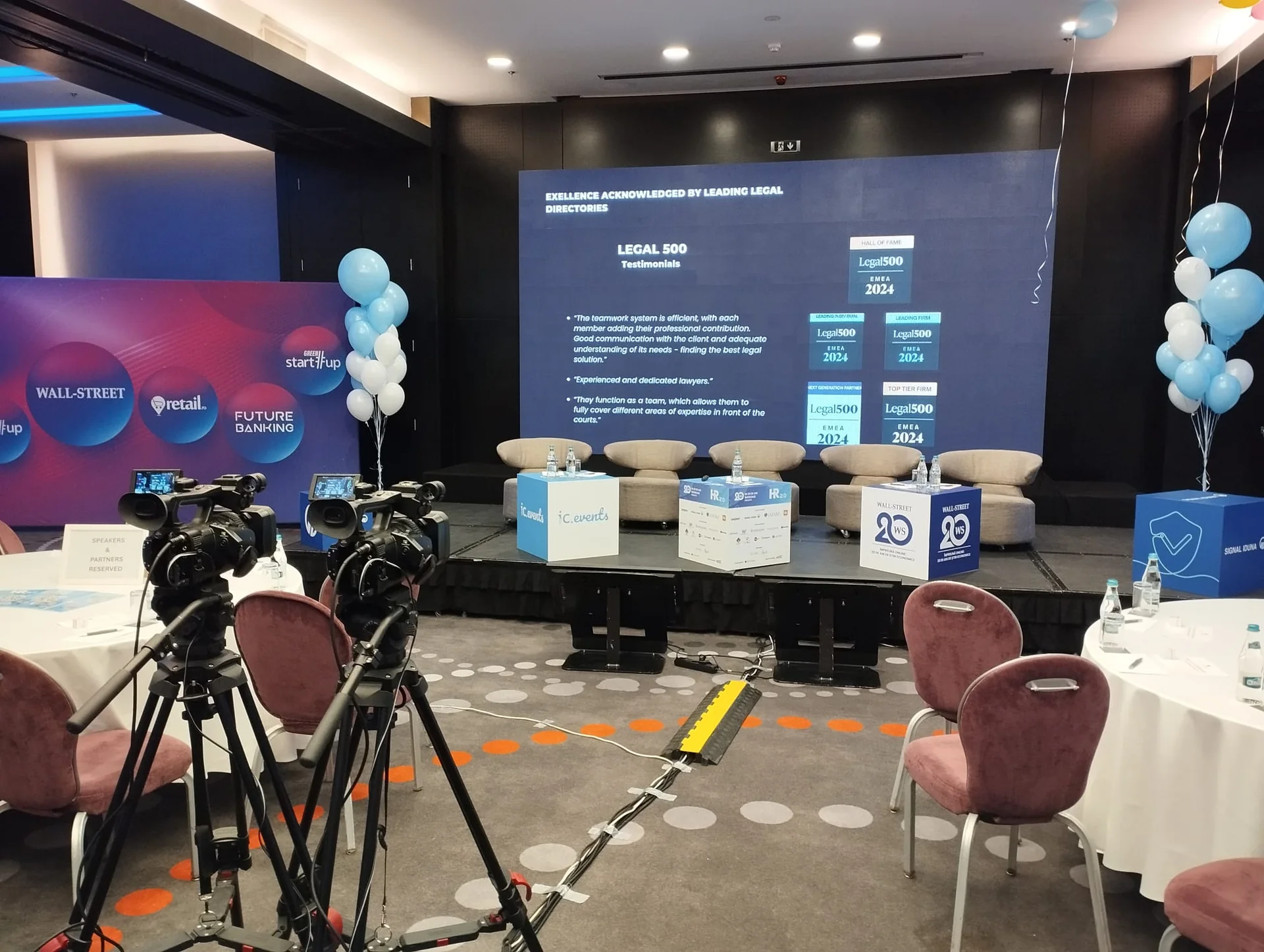 Two video cameras facing the HR 2.0 stage and presentation screen at Sheraton Bucharest.