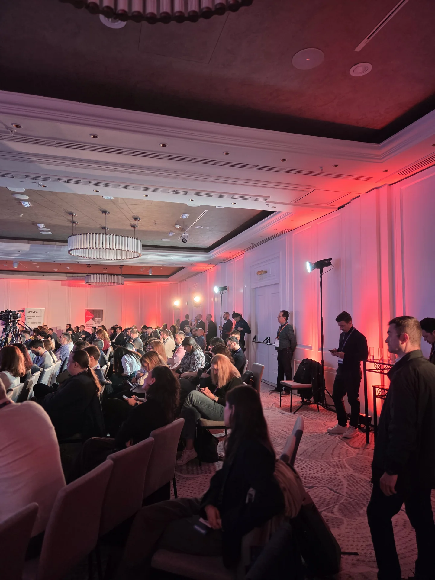 Audience and red architectural lighting during the Netopia event at Marriott Bucharest.