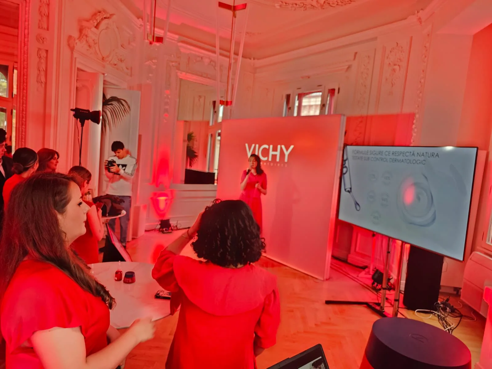 Guests around a Vichy branded event installation with a professional display and red ambient lighting at Mitza Biciclista in Bucharest.