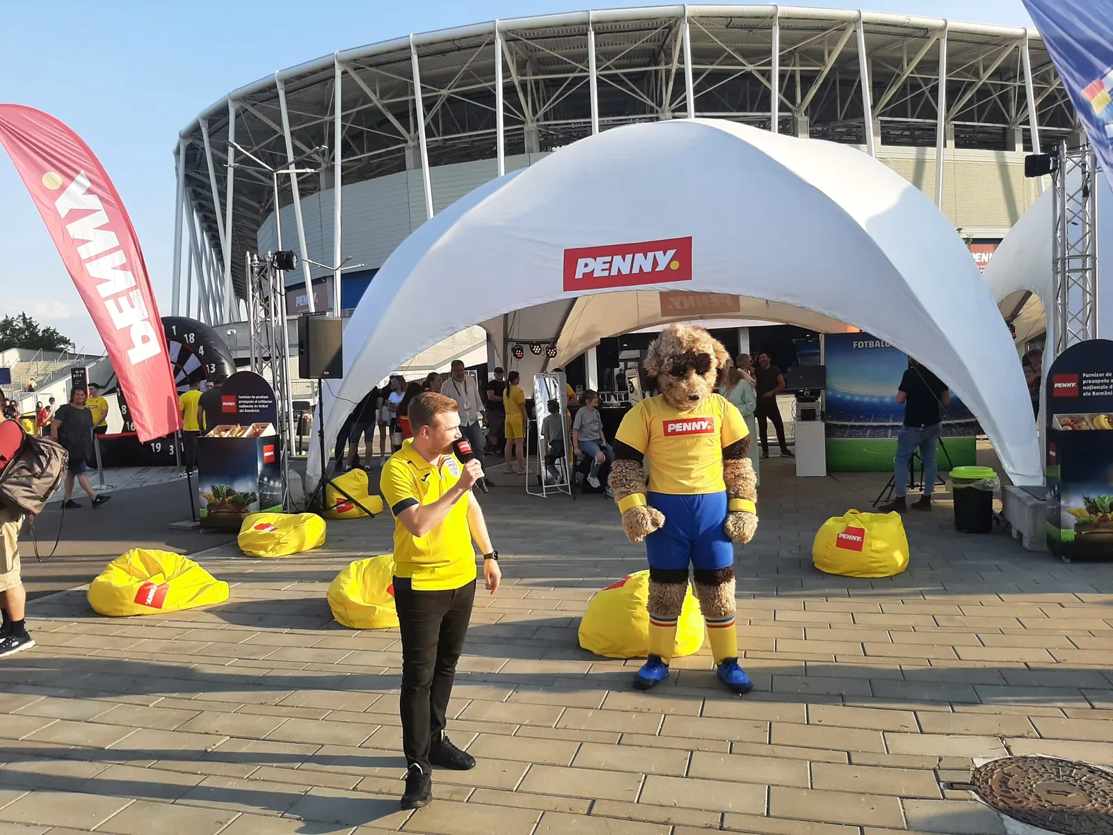 PENNY activation tent outside Ghencea Stadium in Bucharest with branded seating and event staff.