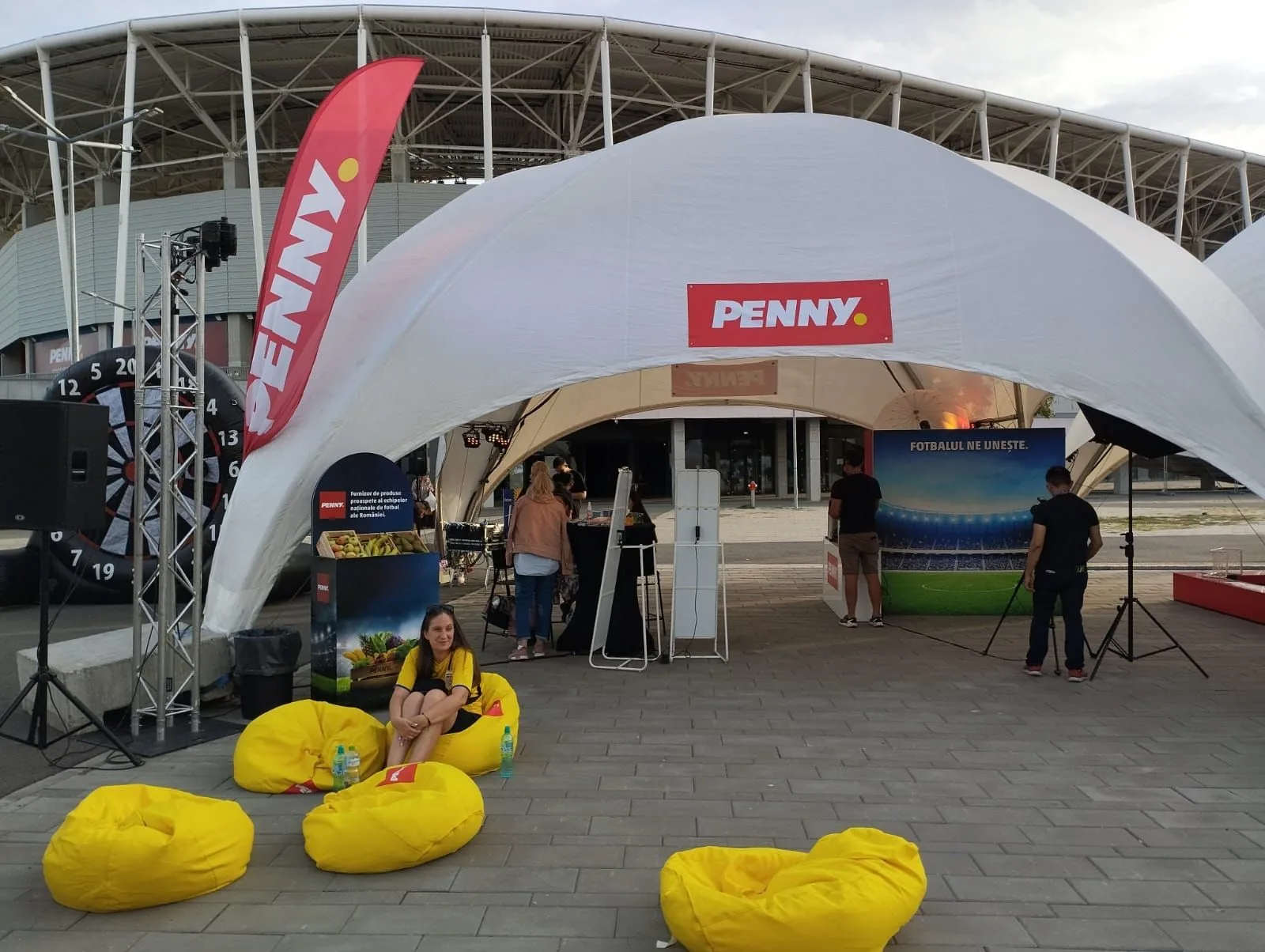 PENNY brand activation tent outside Ghencea Stadium in Bucharest with branded seating and event equipment.