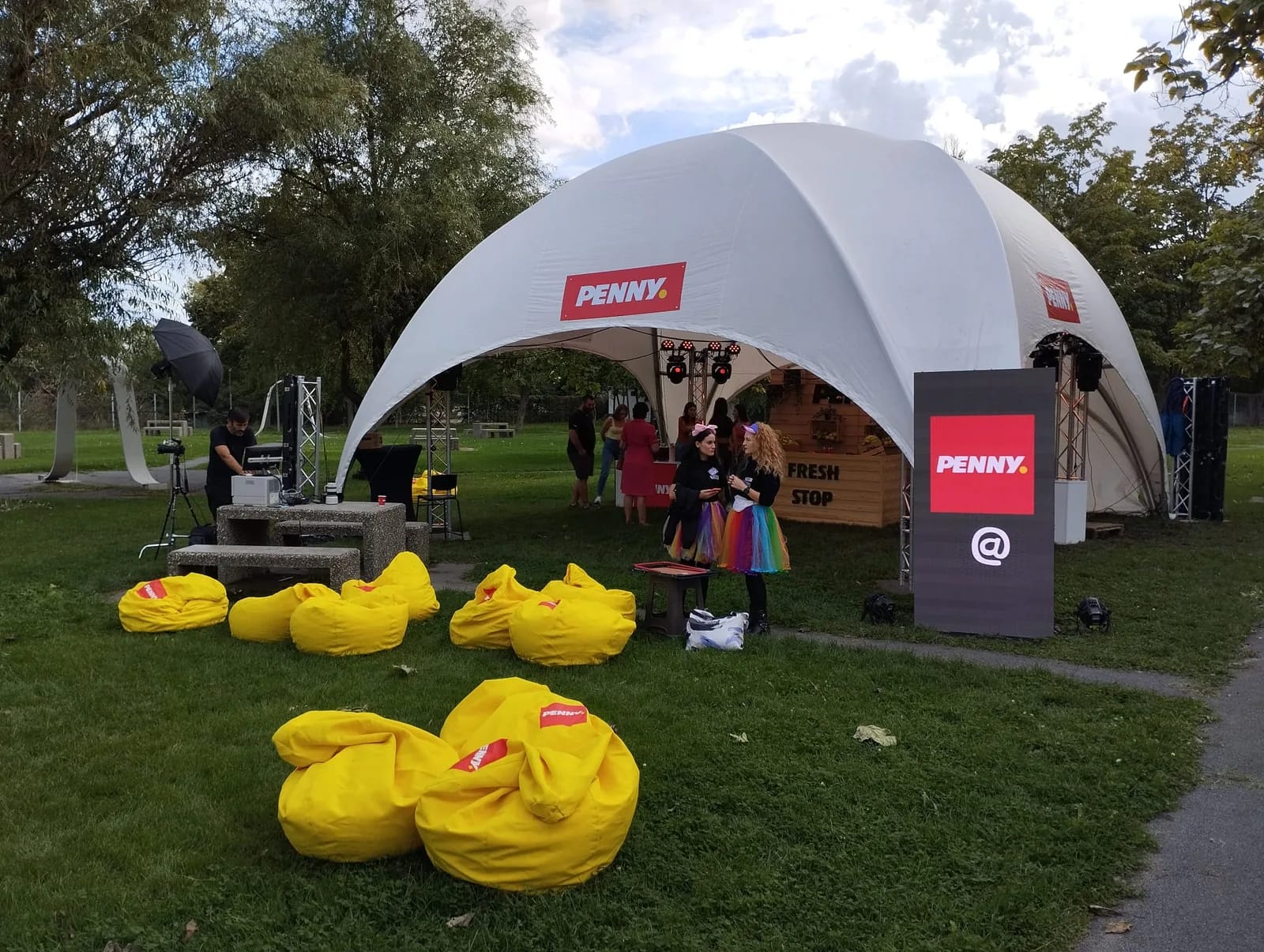 Daytime PENNY festival activation in Galati with the branded tent, yellow seating and digital display.