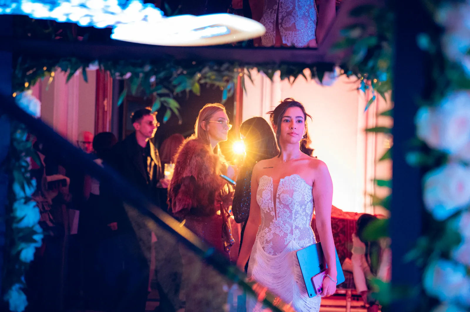 Model in a white dress beside the rose-covered diamond installation