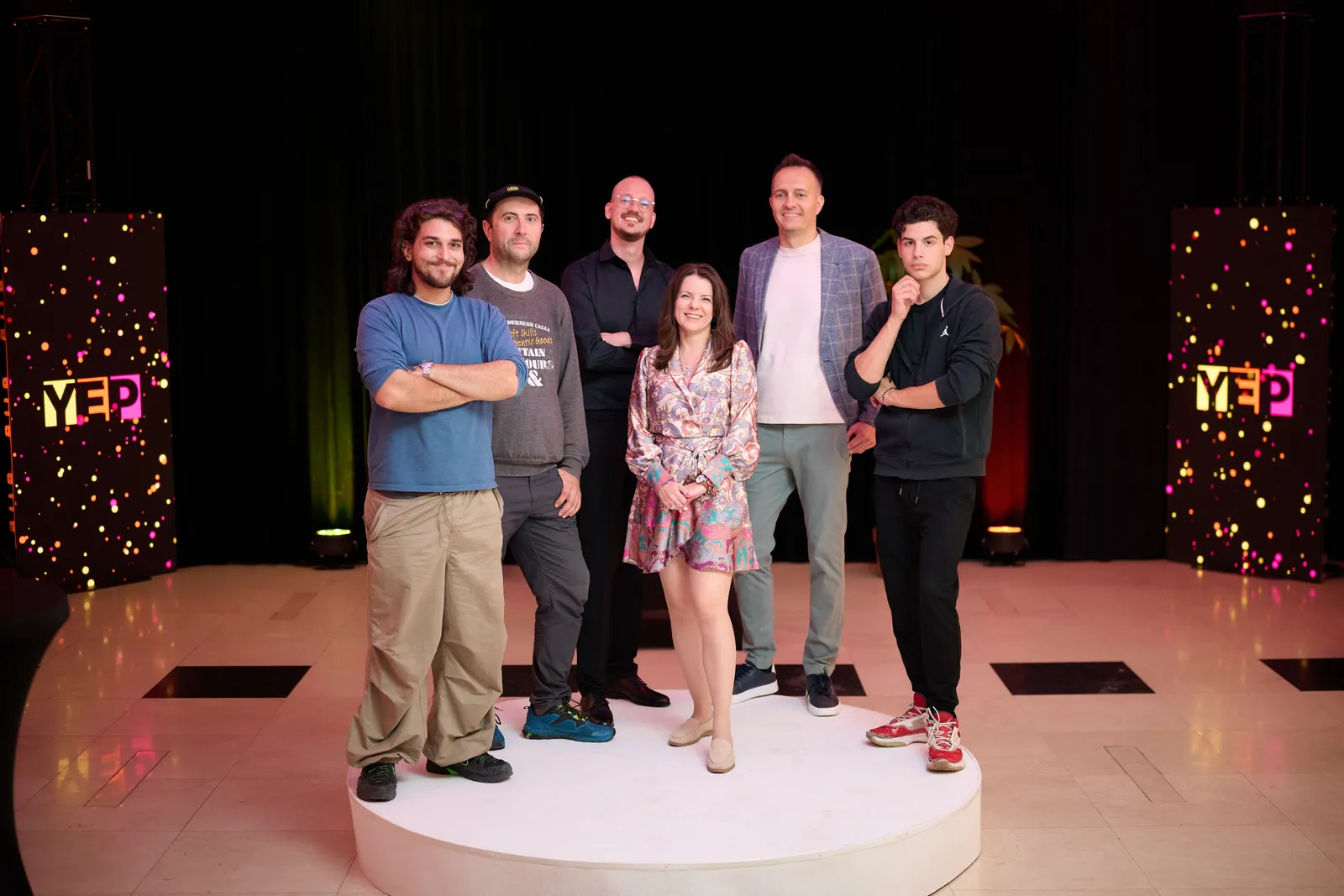 The team on the round stage, framed by the YEP letters